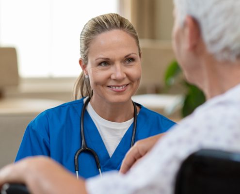 Smiling nurse in front of patient